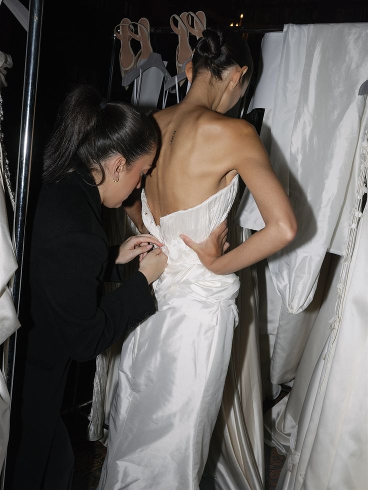 Artists helping the bride into her gown