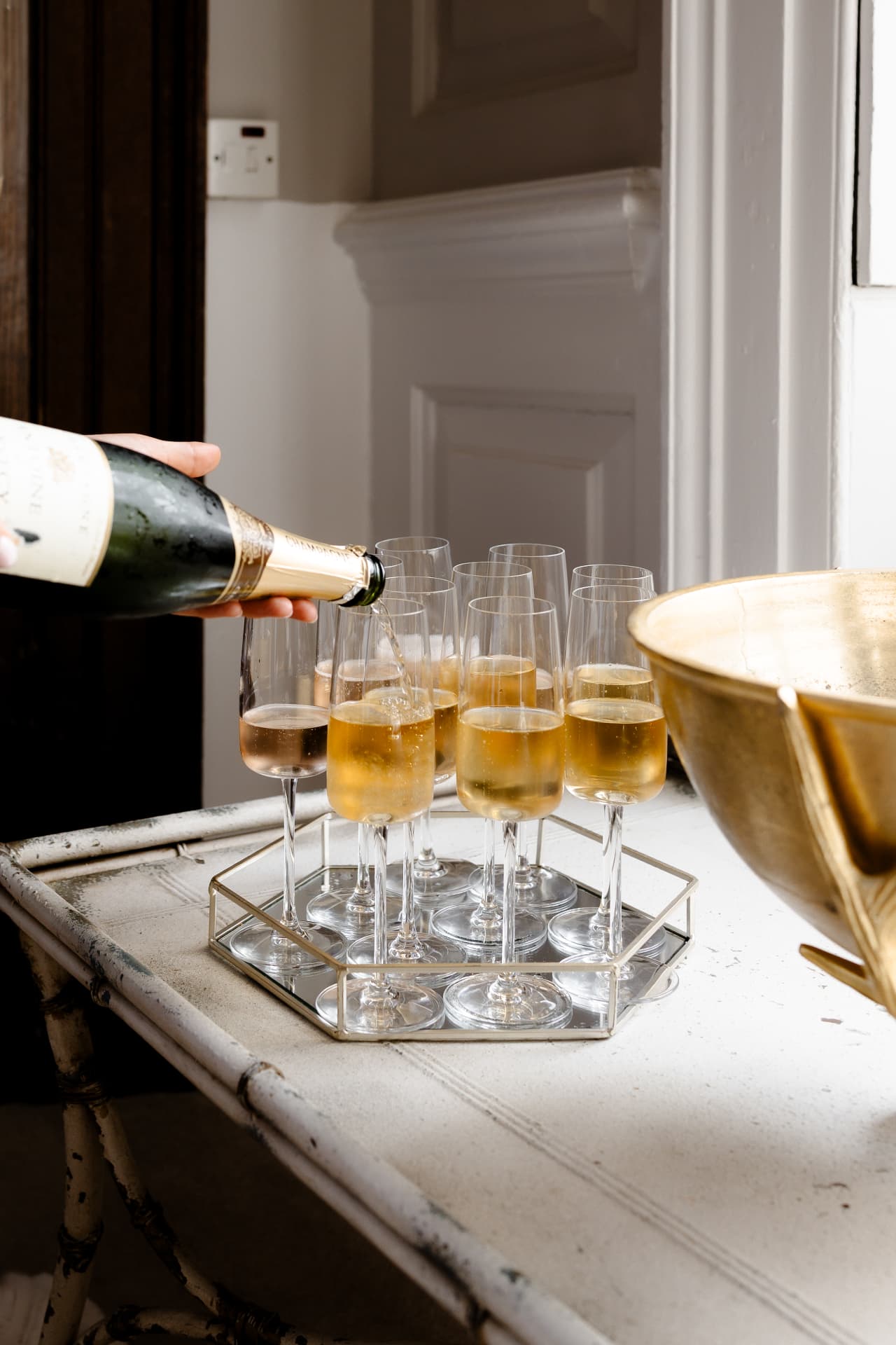 Champagne poured into flutes on a mirrored tray